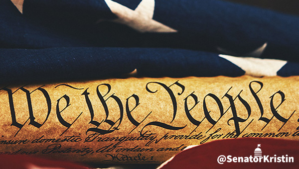 The wording “We the People” from the Constitution’s preamble wrapped in the American flag