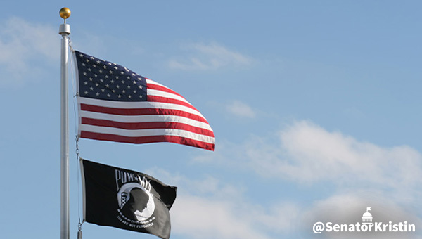 A US flag and a POW-MIA flag fly on the same flagpole