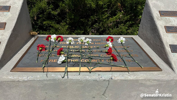 Memorial with roses laid on top of plaque