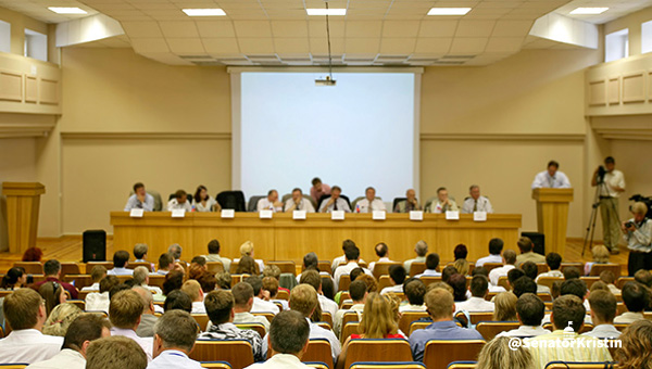 A local government meeting with many attendees.