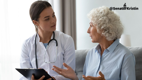 Medical worker speaking with an elderly woman.