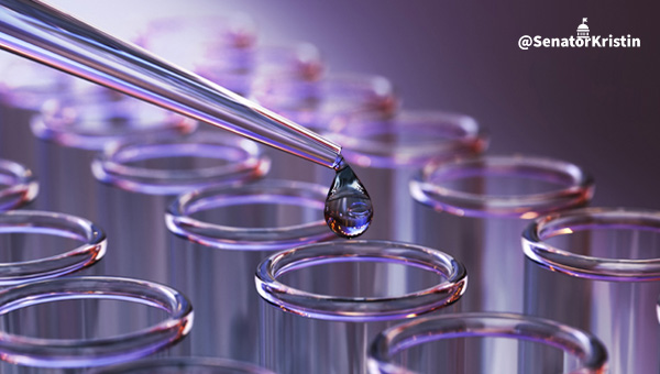 A dropper putting liquid into a test tube.