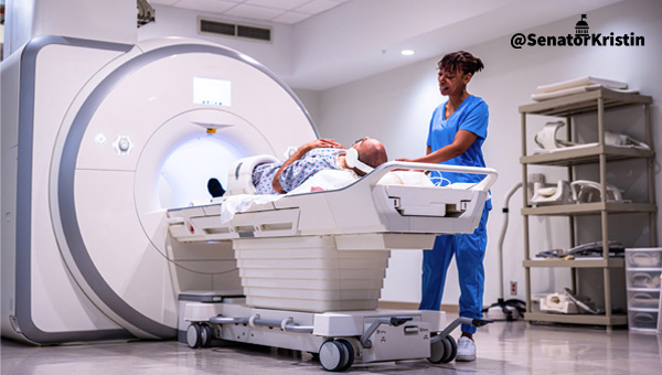 A healthcare worker placing a man into a medical imaging machine.