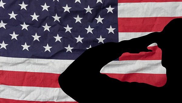 The United States flag with a silhouette of a military person saluting. &nbsp;