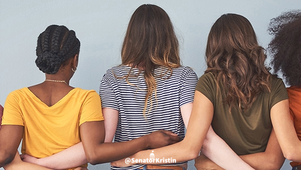 Women with their arms around each other.