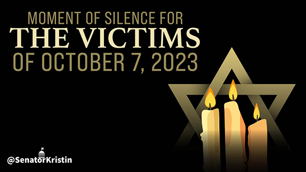 Lit candles in front of the Star of David with text which reads “Moment of Silence for the Victims of October 7, 2023”.